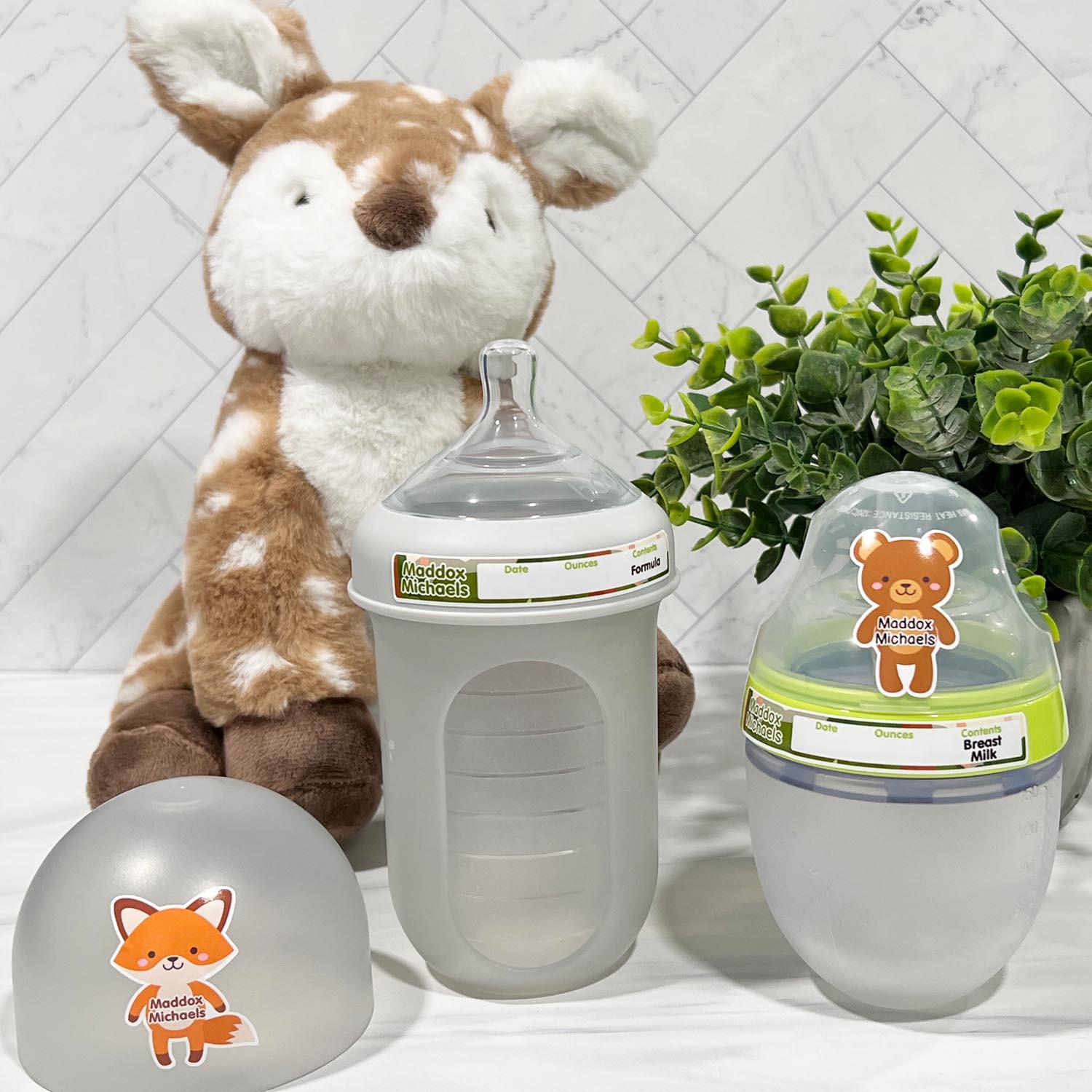 Sticky Monkey Slim Rim labels applied to the plastic collar of a Comotomo silicone bottle